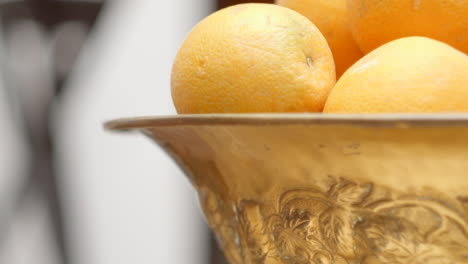 Tilt-Up-Reveal-Oranges-in-a-Decorated-Brass-Bowl-Close-Up-Soft-Focus