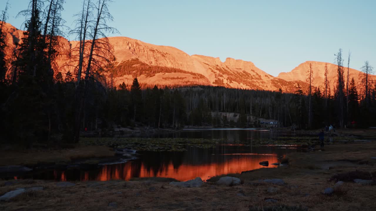 toma de paisaje de lapso de tiempo del hermoso lago de mariposas rodeado de grandes montañas rocosas y pinos dentro del bosque nacional uinta wasatch cache en utah durante una puesta de sol de verano