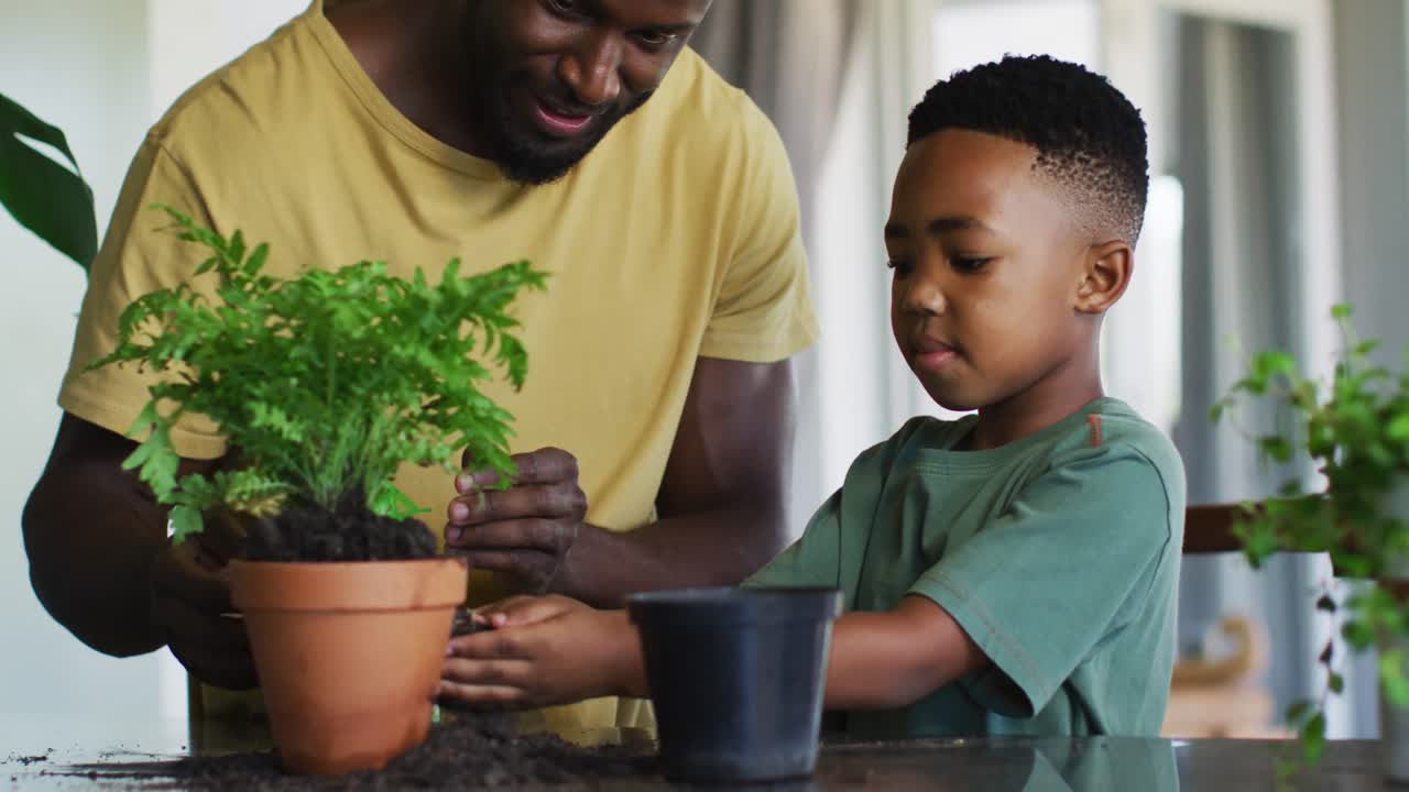 African american boy adding new soil to the plant pot at home