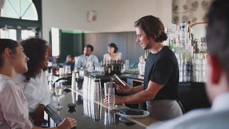 Barkeeper-Serviert-Zwei-Geschäftsfrauen,-Die-Sich-Zu-After-Work-Drinks-Treffen