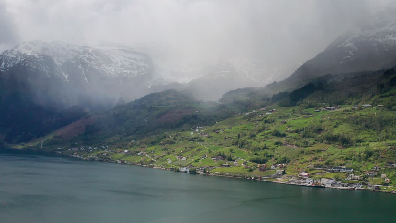 delgadas nubes brumosas colgando sobre el agua del fiordo de hardanger