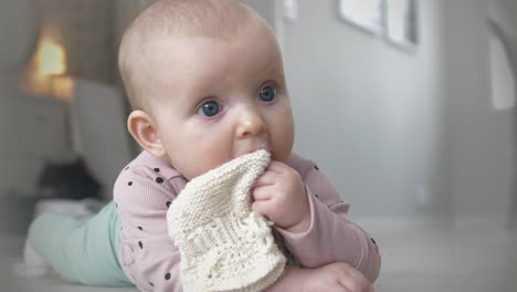 niña con ojos azules jugando en el piso