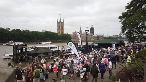 climate change protestors lobby along the banks of the thames and outside the houses of parliament as part of the time is now protest