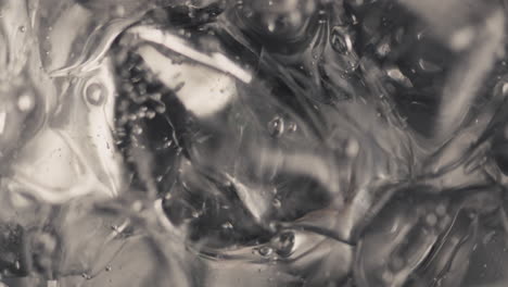 ice cubes sparkling water spinning closeup in slow motion. beverage concept