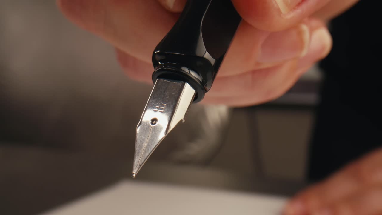 Close-up de uma caneta-tinteiro desenhando linhas em um papel branco