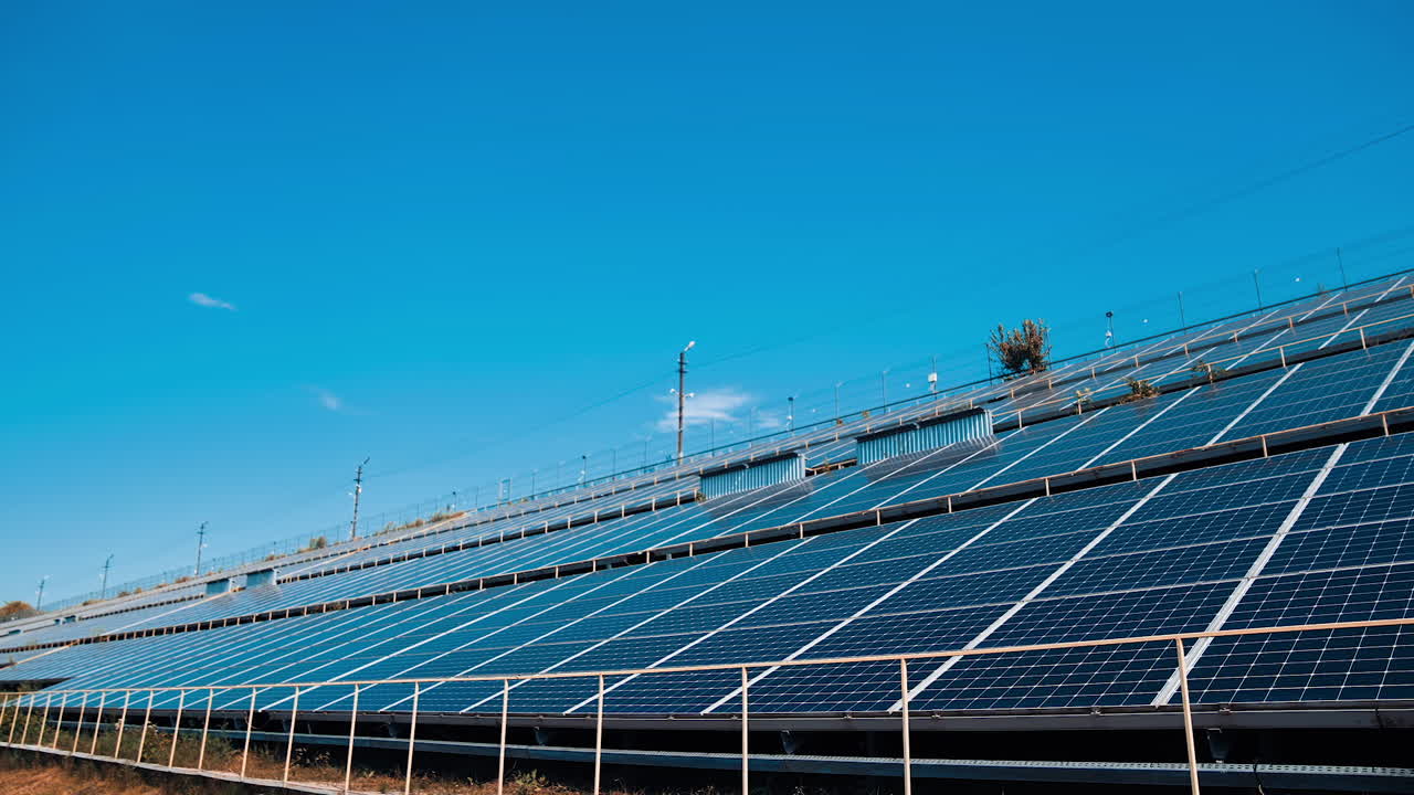 Alternative source of energy. Blue solar panels get clean ecological energy from the sun. Modern solar farm on clear sky background.