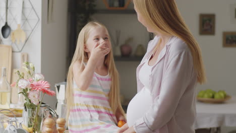 pregnant mother and daughter in the kitchen