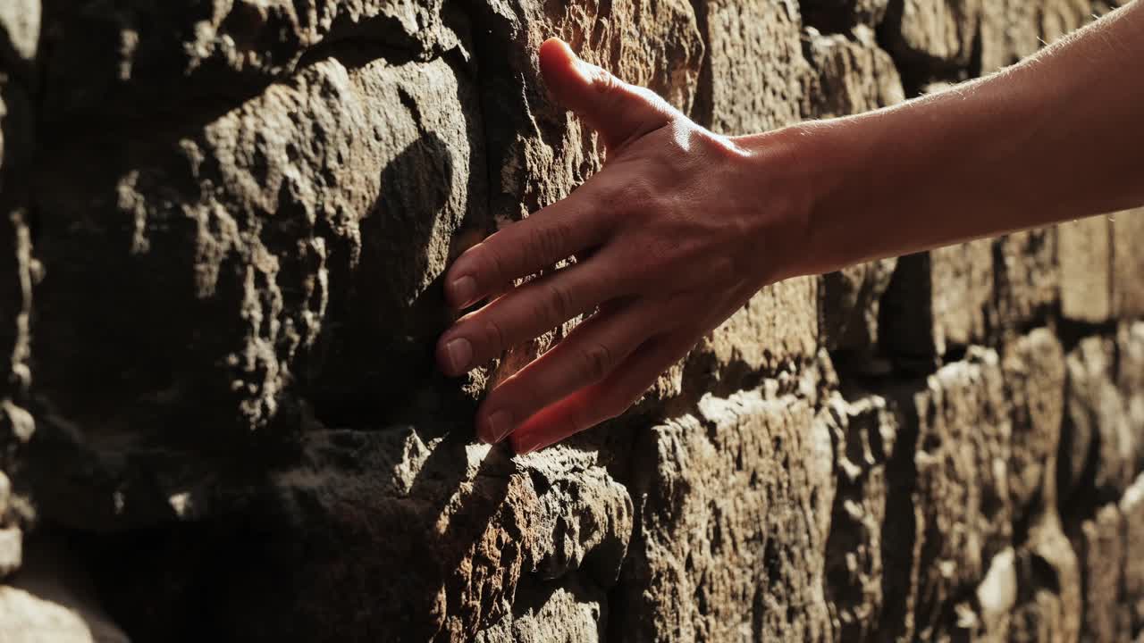 Touching old castle wall, Happy tourist man in Barcelona, Spain. Vacation exploring interesting places to travel, student vacation, young man portrait walking in gothic square, old european city