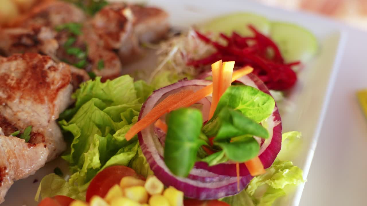 deliciosas piezas de cerdo y ensalada fresca servida en el restaurante, de cerca