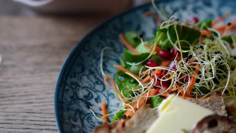 close up of shiny fork take cherry tomato slice from vegetarian salad dish