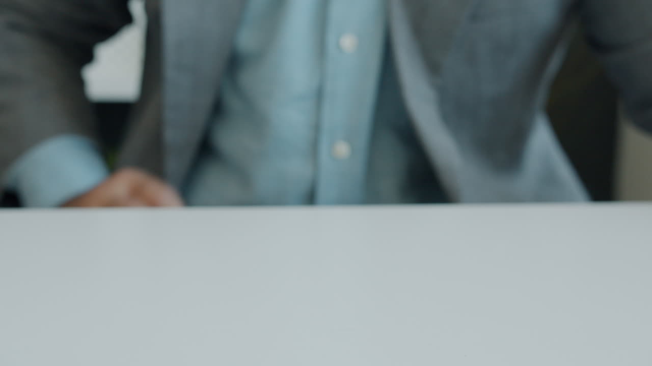 Business man clenching fist on a table
