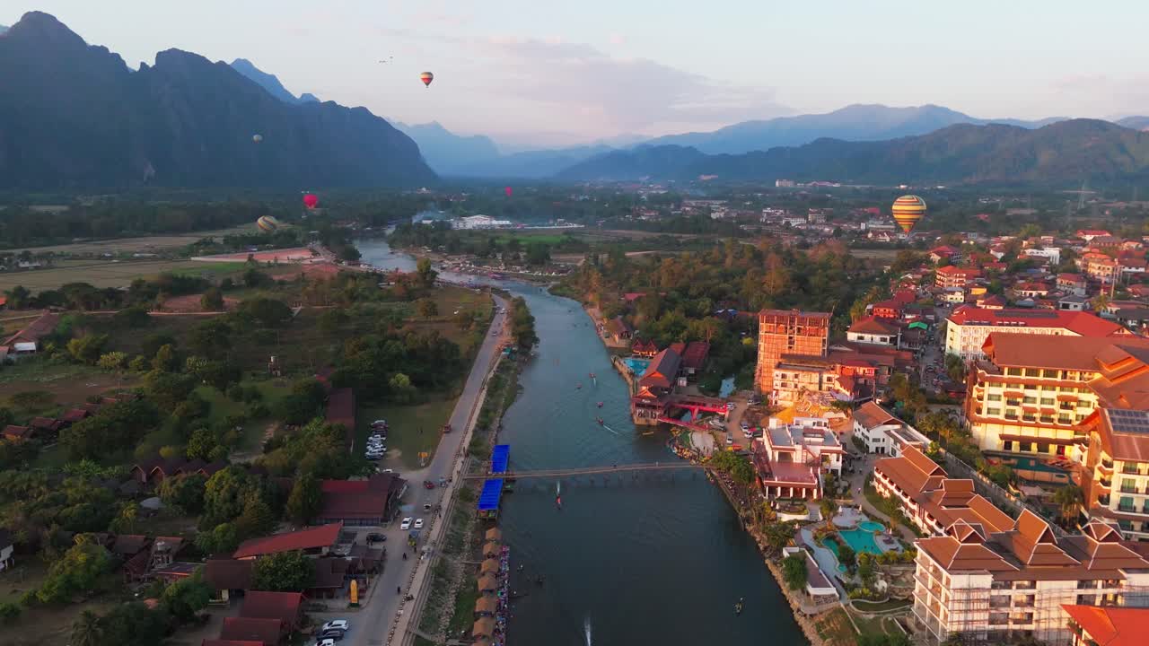 Veduta aerea di Vang Vieng, Laos, con un fiume che serpeggia attraverso un vivace villaggio e colline panoramiche