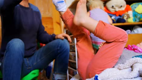 Father-removing-his-sons-socks-in-bedroom-at-home-4k