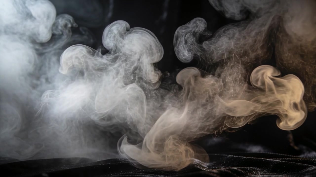Columnas de humo gris a la deriva formando remolinos y desvaneciéndose en el estudio, alimentadas por una fuente fuera de cuadro.