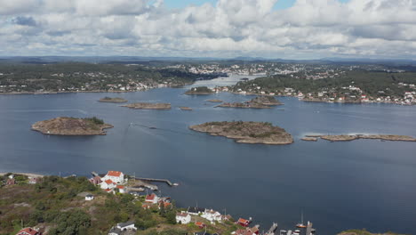 small islands by seaside town of arendal, norway, aerial pull back