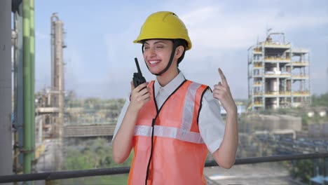 happy indian female architect giving instructions on walkie talkie