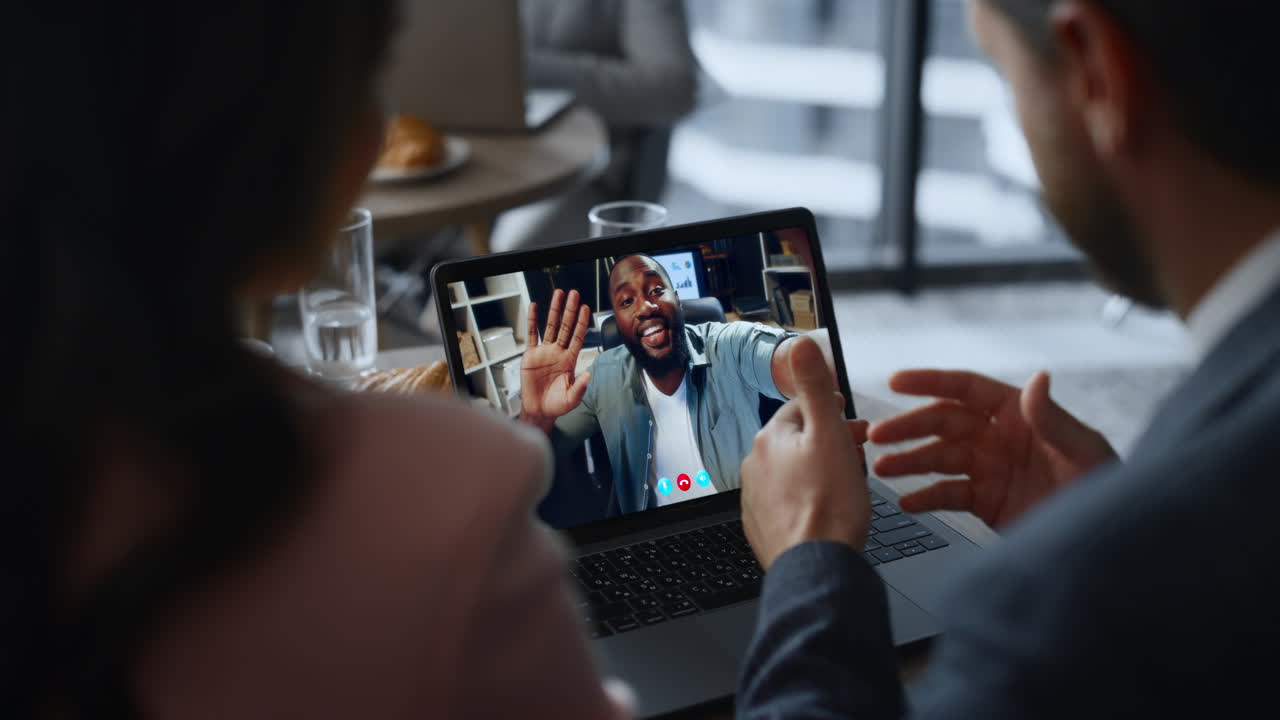 Happy colleagues talking laptop video call in cafeteria closeup. Team conference