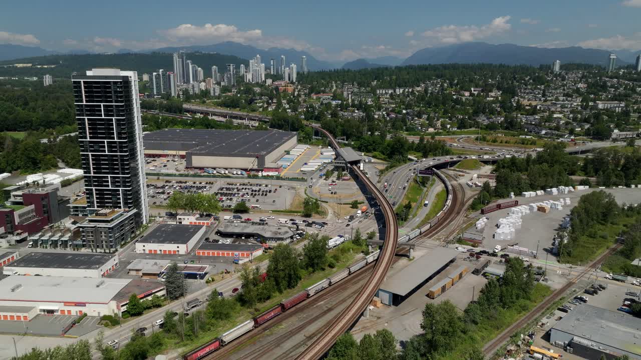 Long Freight Train Traveling Through New Westminster, British Columbia, Canada. - aerial shot