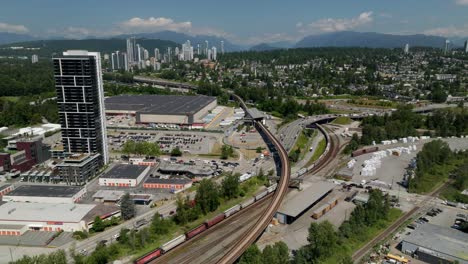 long freight train traveling through new westminster, british columbia, canada. - aerial shot