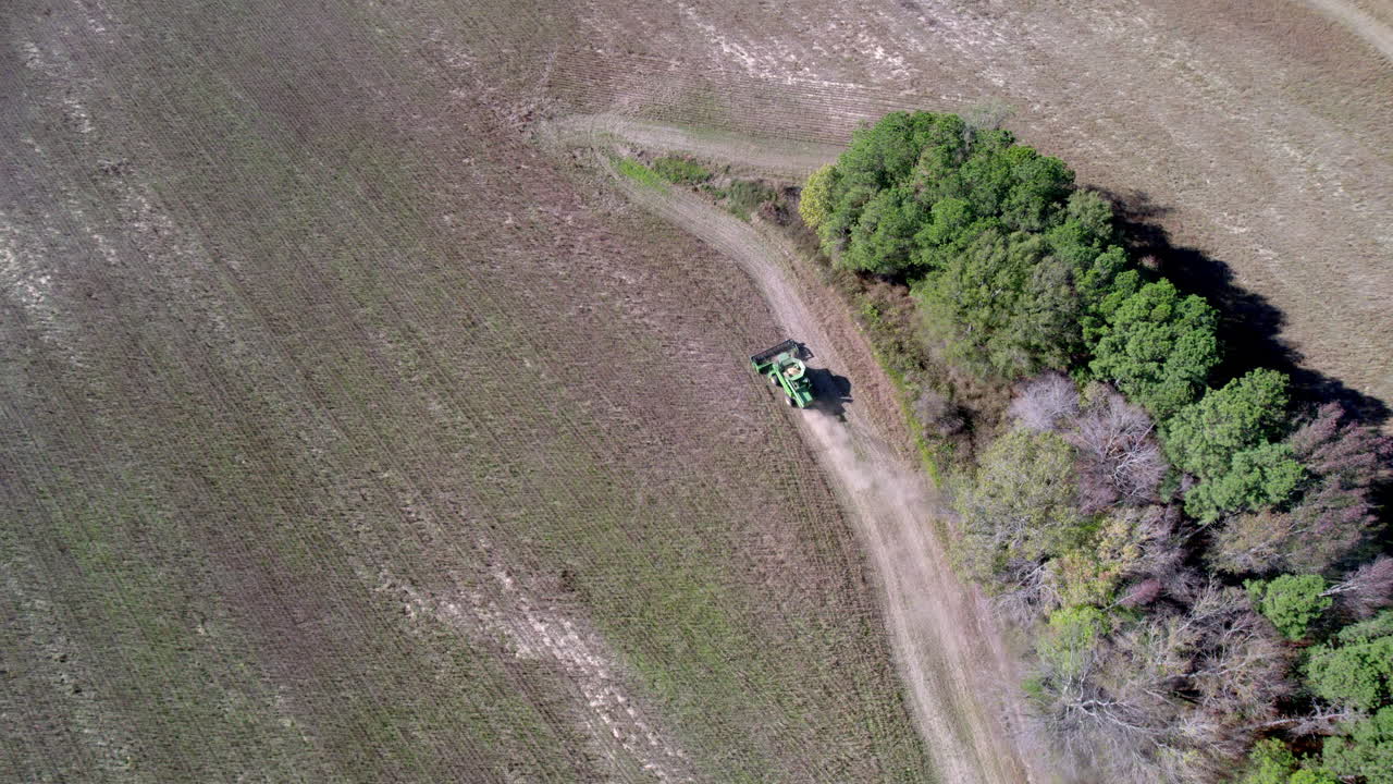 수확기나 트랙터로 농장에서 콩을 수확하는 드론 영상, 하향 공중 촬영
