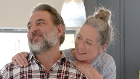 happy mature couple enjoying cozy moment at home, smiling and embracing warmly