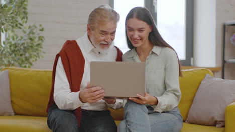 grandparent and granddaughter using laptop