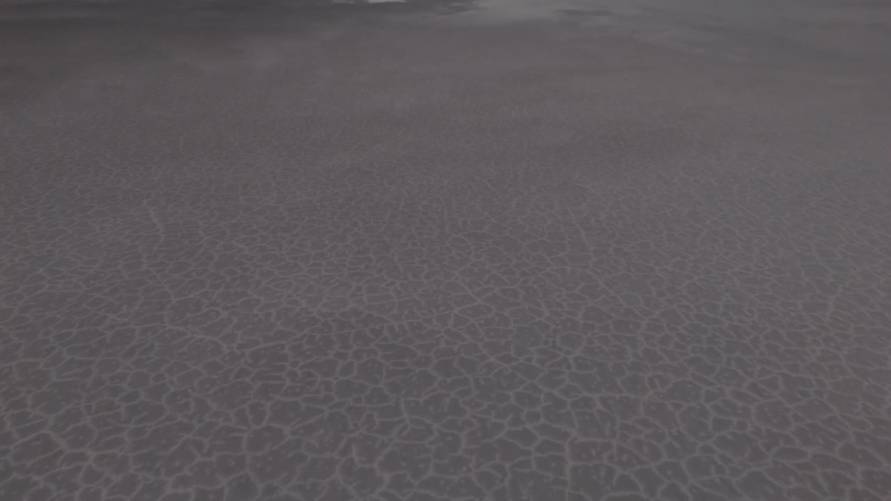 drone lenta aproximación baja sobre las salinas de bonneville con agua que refleja el cielo y las nubes