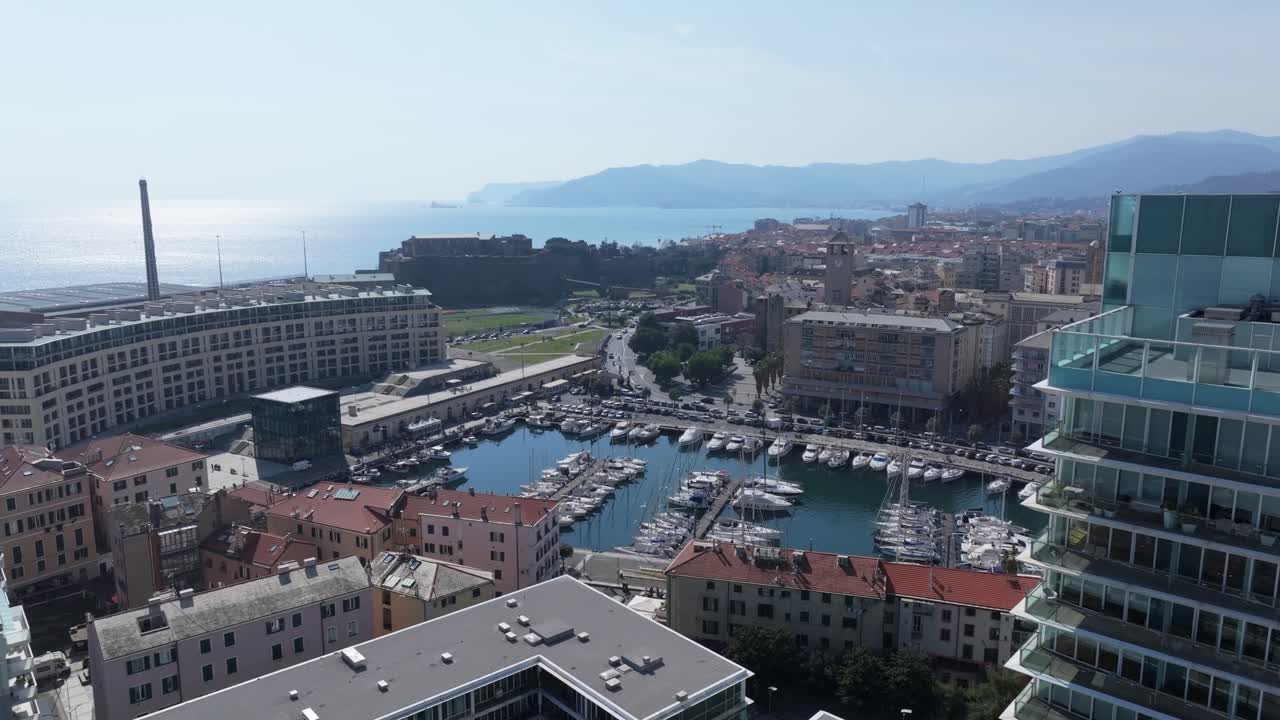 Modern marina and cityscape of Savona with coastal skyline and glass tower