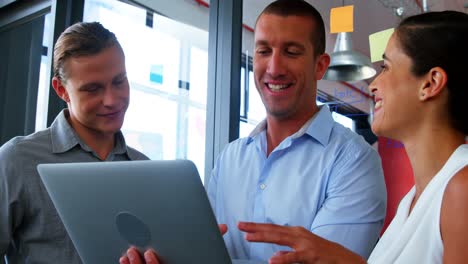 Business-executives-discussing-over-laptop