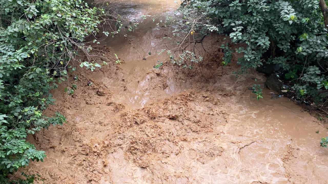 aéreo: río muy fangoso, agua corriente marrón, abuja, nigeria, revelación inclinada hacia arriba