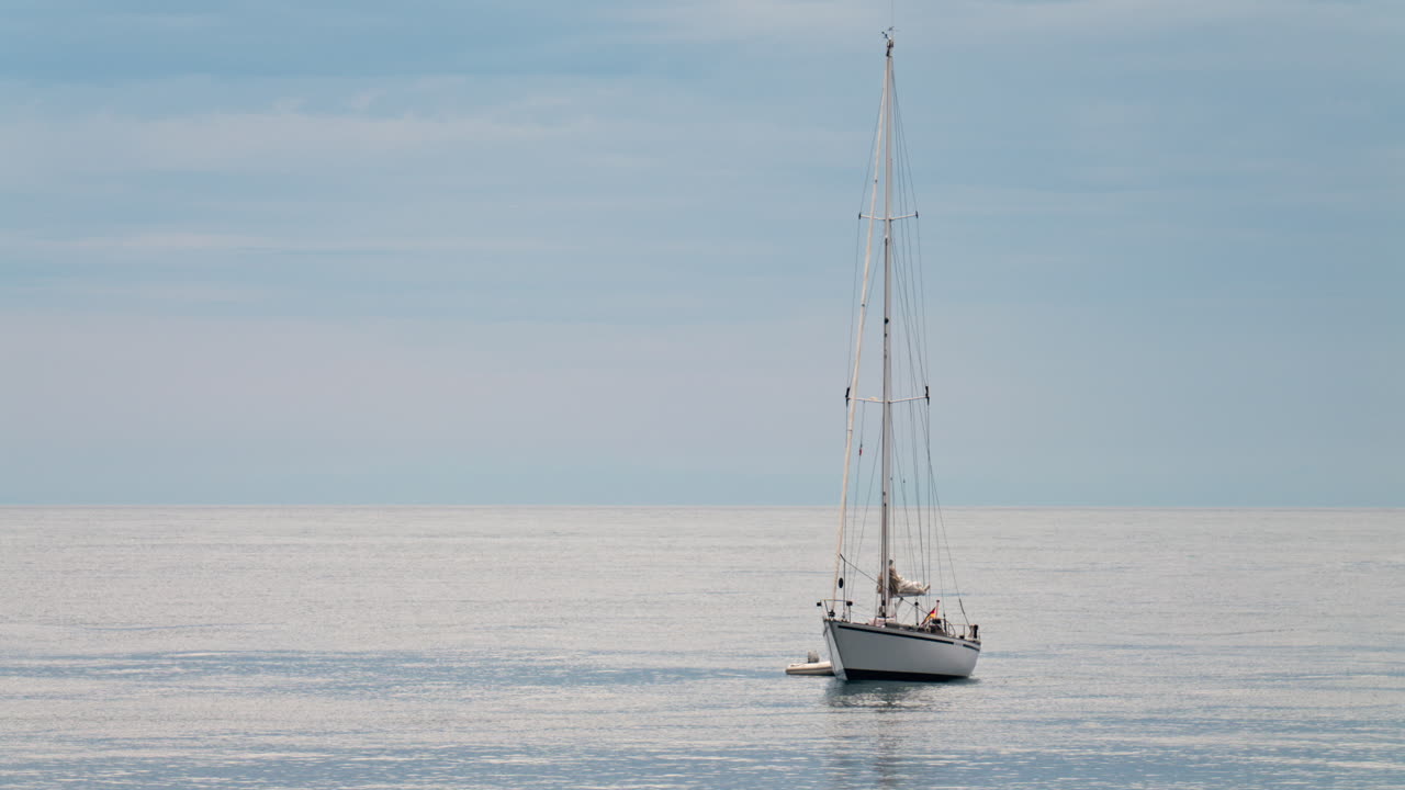 Distant view of a white boat floating on the Mediterranean Sea in daylight
