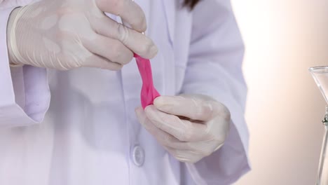 el científico prepara un globo para el experimento de reacción química