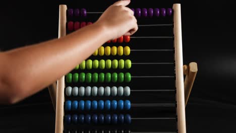 hand manipulating beads on a colorful abacus