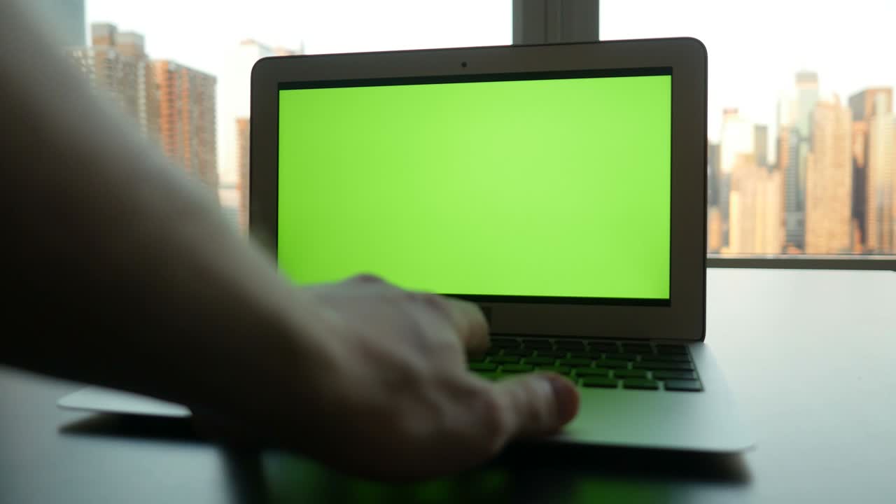 portátil de negocios con pantalla verde monitor de clave croma y fondo de paisaje urbano.