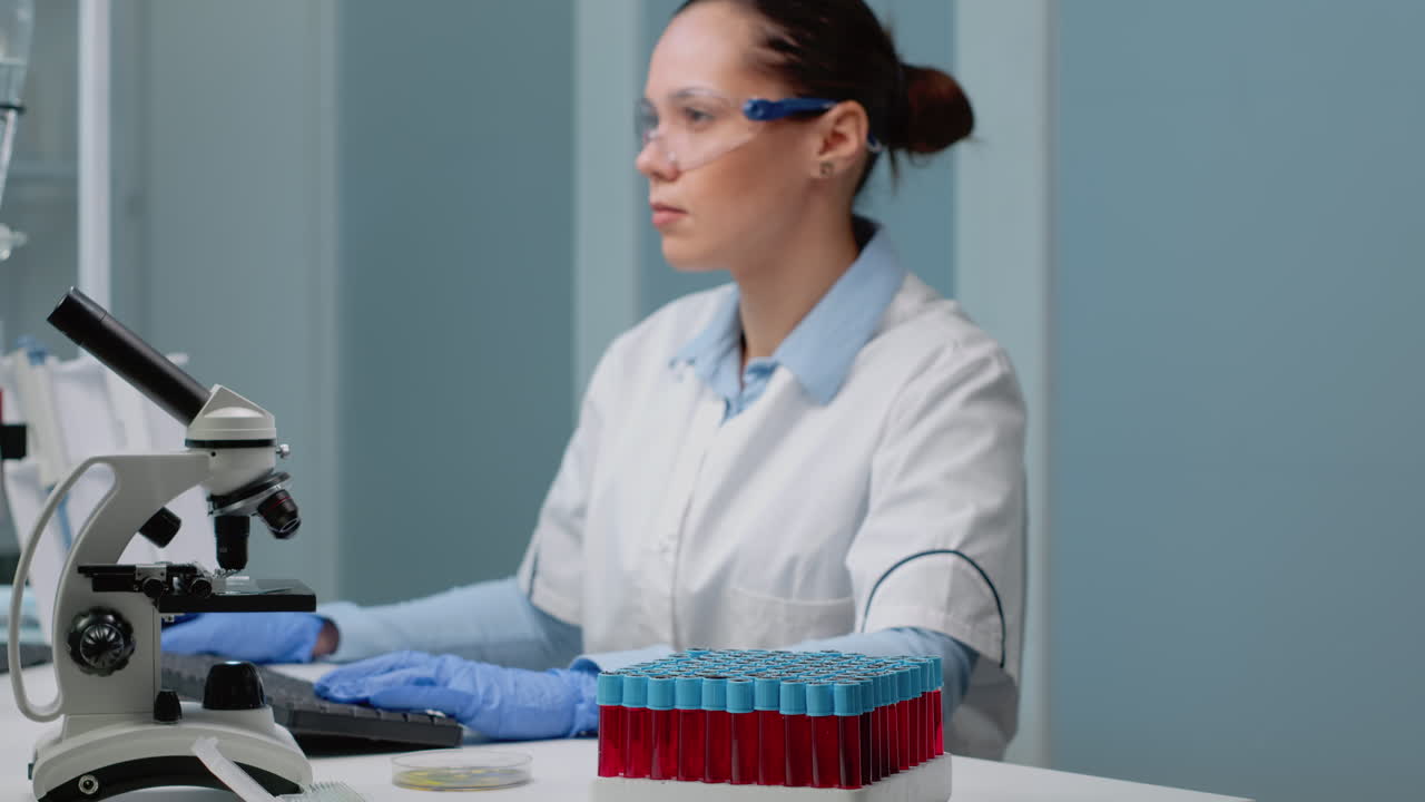 Scientist working in a lab with a microscope and test tubes