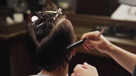 Primer-Plano-De-La-Mano-De-Un-Barbero-Peinando-El-Cabello-De-Un-Hombre-Largo-Con-Un-Peine