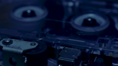 la luz se desvanece en la grabadora de microcassette girando el rodillo de presión con carretes de cassette en segundo plano.