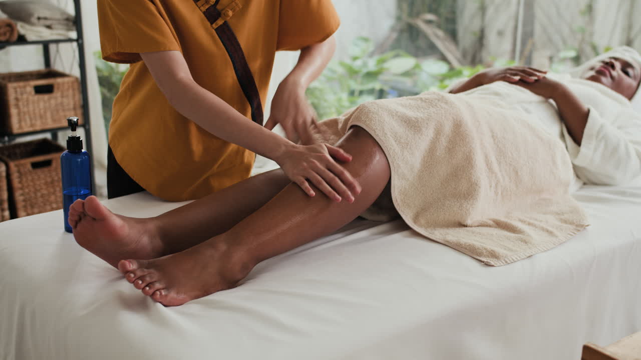 Donna che si rilassa nel centro benessere durante un massaggio alle gambe