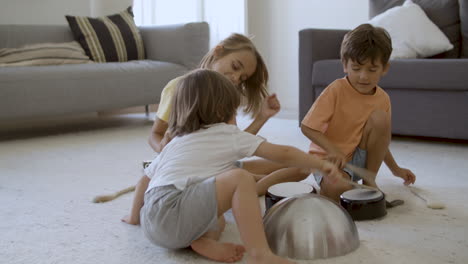 caucasian girl and boys knocking bowls and playing together