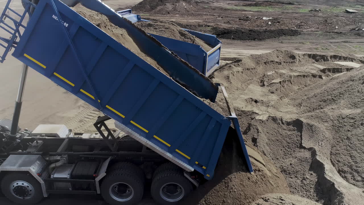 camiones de descarga cargando arena en un sitio de construcción
