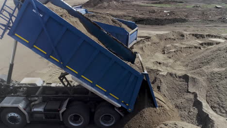 camiones de descarga cargando arena en un sitio de construcción