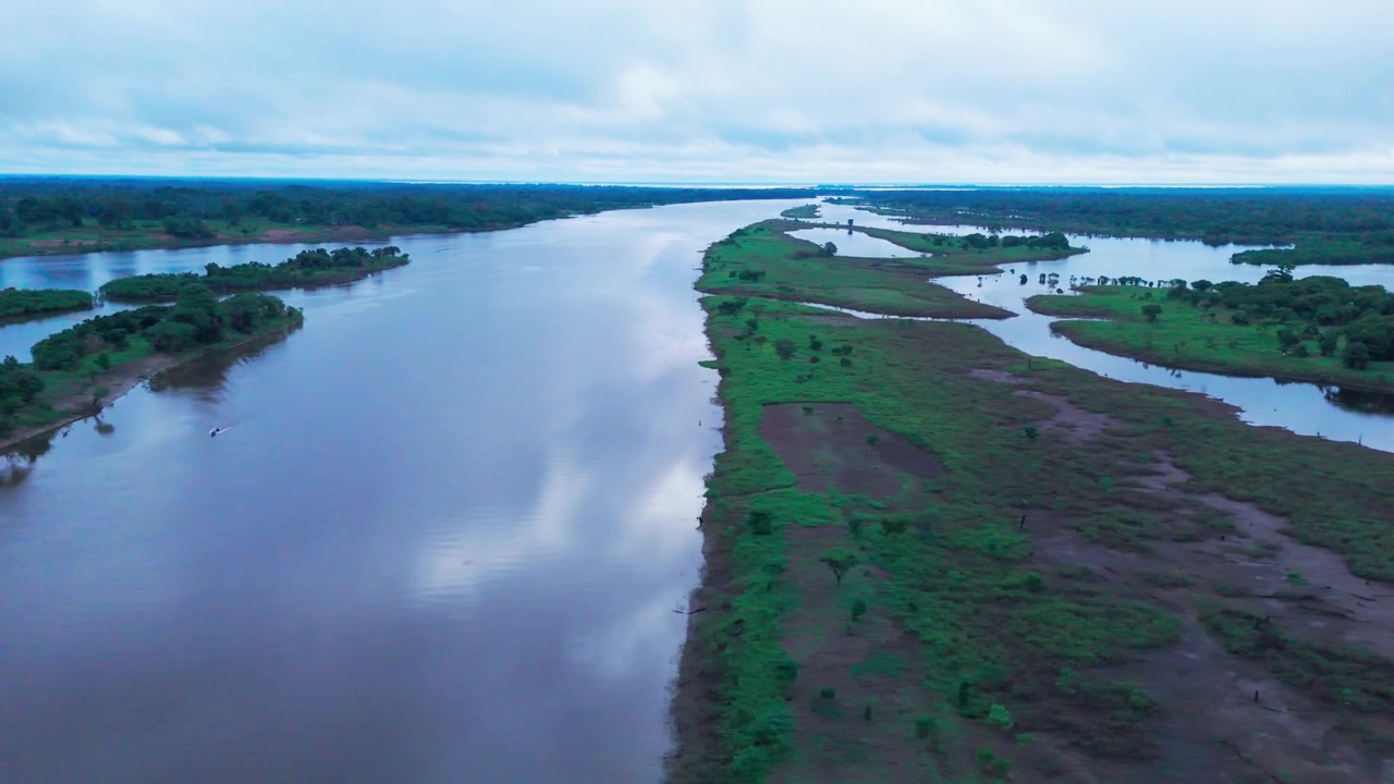 Paesaggi tropicali e corsi d'acqua fluviali nel bacino amazzonico brasiliano durante la sera, con vegetazione lussureggiante e riflessi di nuvole, veduta aerea panoramica.