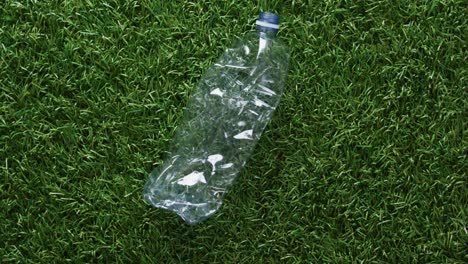 Close-up-of-plastic-bottle-trash-on-grass-background,-with-copy-space