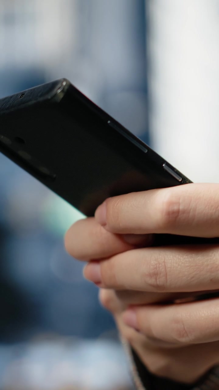 Video verticale. Primo piano di una donna d'affari che digita sullo schermo dello smartphone all'aperto
