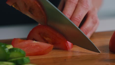 a person cutting vegetables tomatoes in a kitchen on a sunny day