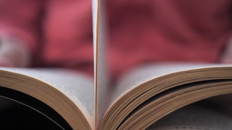 Uno studente legge un libro cercando informazioni e sfogliando le pagine.