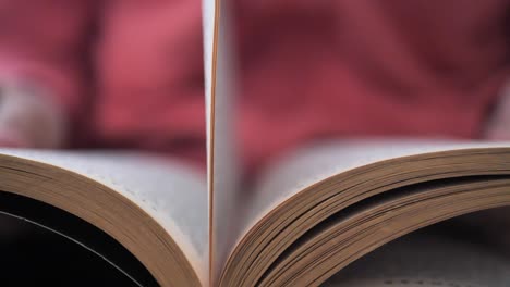 a student reads a book searching for information and flipping pages