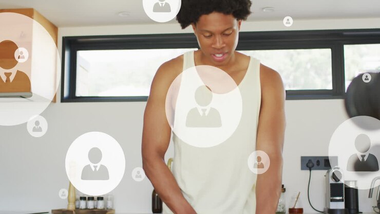 Animation of multiple profile icons over african american athlete cutting fruit in kitchen at home
