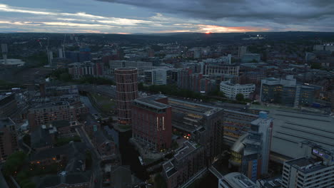 Establecimiento-De-Una-Toma-De-Drones-Del-Centro-De-La-Ciudad-De-Leeds-Alrededor-De-La-Estación-De-Tren-De-Leeds-Con-Poca-Luz-Y-Puesta-De-Sol-Naranja-En-La-Distancia-Al-Oeste-De-Yorkshire,-Reino-Unido