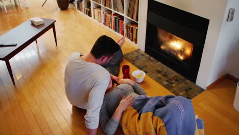 couple relaxing near fireplace in living room